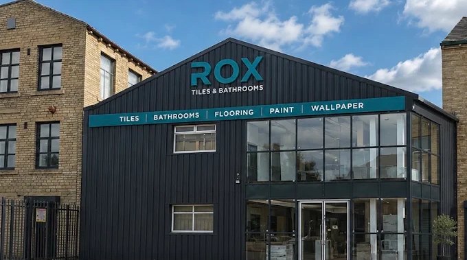 The ROX Tiles & Bathrooms showroom at Brooksmouth Mills, Clifton Road, Brighouse — charcoal clad building with water-blue signage
